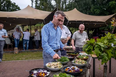 Bezoeker van zakelijk evenement schept op van saladebuffet