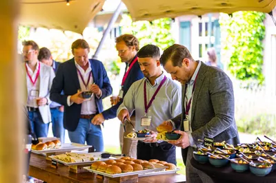 Bezoekers van een event pakken tijdens de lunch broodjes en salades onder de Stretchtent