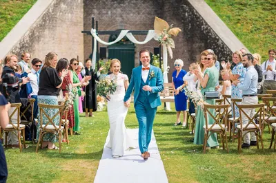 Bruidspaar loopt af na ceremonie voor de poterne