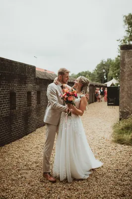 Bruidspaar omhelst elkaar romantisch bij kazematten
