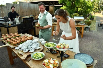 Bruidspaar schept op van buffet tijdens barbecue