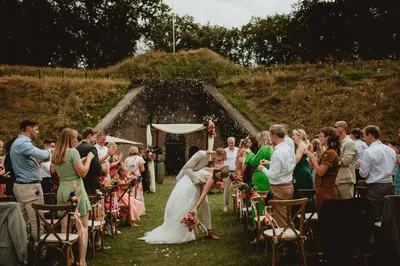 Bruidspaar zoent in gangpad na ceremonie voor de poterne