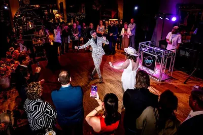 Dansend bruidspaar tijdens feest met dj in de loods