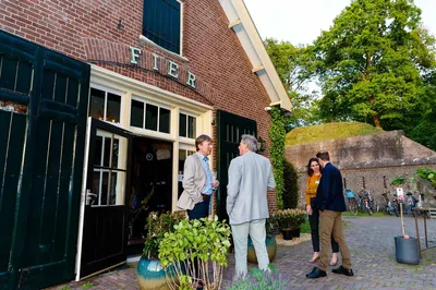 De Loods met een aantal pratende mensen ervoor
