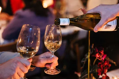 Glazen wijn worden gevuld door personeel van Fier Bussum