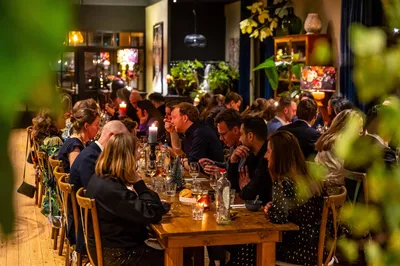 In De Loods een gezelschap aan het kerstdiner aan een lange tafel