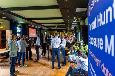 In De Loods staan diverse bezoekers van een event met elkaar te netwerken