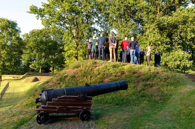Kanon en bezoekers rondleiding bij het historische Unesco-fort omgeven door groen
