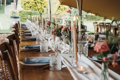 Lange sfeervol aangeklede dinertafel onder de stretchtent voor bruiloft