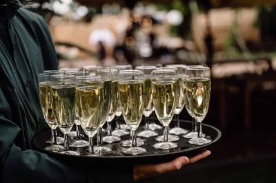 Medewerker met plateau vol champagneglazen voor proostmoment tijdens bruiloft