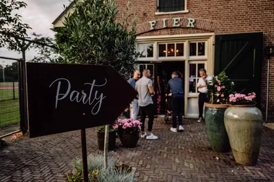 Party bordje wijst richting de loods waar ze feesten
