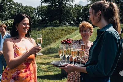 Personeel serveert champagne aan bruiloftsgasten