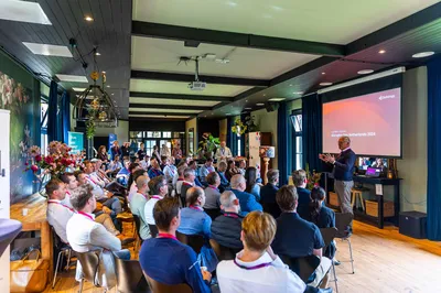 Presentatie met spreker voor een scherm voor deelnemers aan een zakelijke bijeenkomst in De Loods